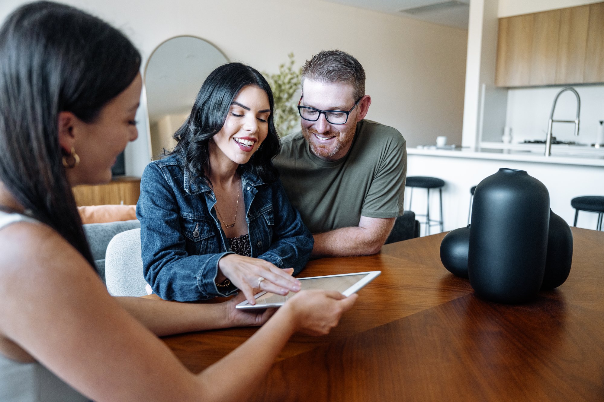 Smiling couple looking at a tablet together, representing customers exploring clean energy upgrades through the BOOM! Power platform Smiling couple looking at a tablet together, representing customers exploring clean energy upgrades through the BOOM! Power platform